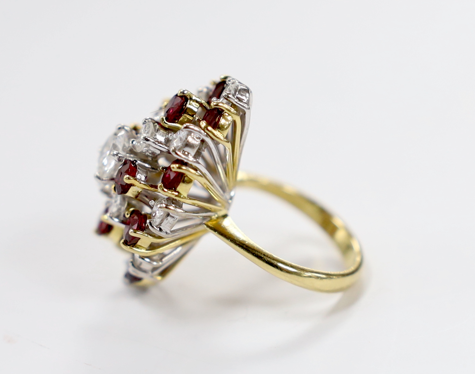 A modern yellow metal, ruby and diamond set oval cluster dress ring, size L/M, gross weight 11.4 grams.
